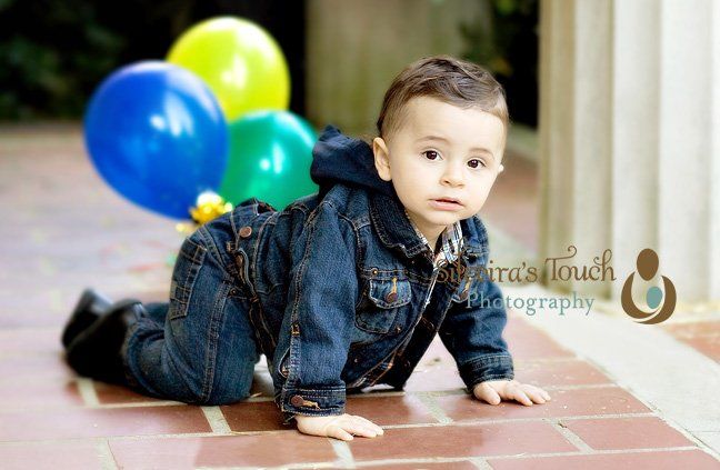 Photo of birthday boy crawling holding balloon