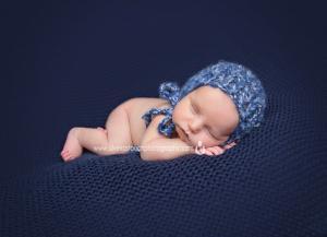 tiny baby boy with sleepy hat in blue blanket