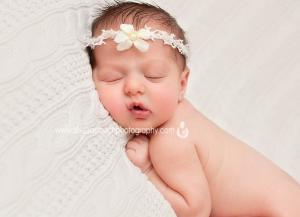 newborn photography in Livingston nj home of baby girl wearing flower headband