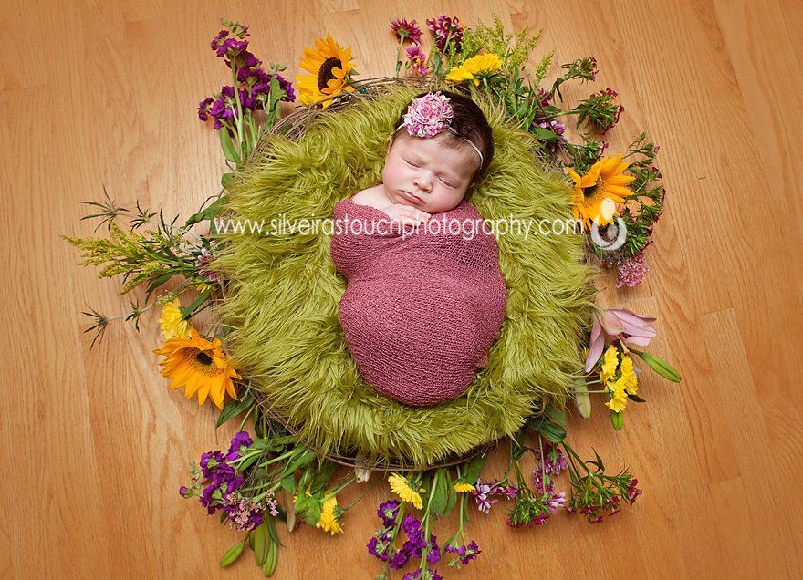 Newborn photography of baby girl on a nest of flowers sleeping