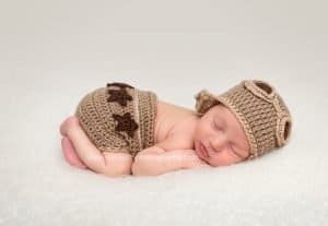 sleeping snuggled baby boy wearing aviator outfit