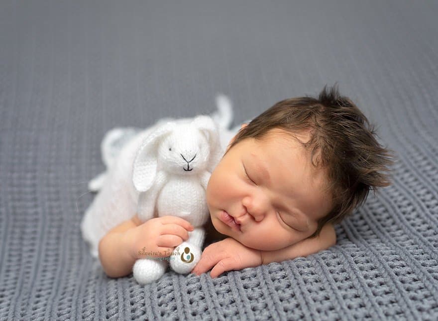 Newborn baby girlsleeping holding bunny photo