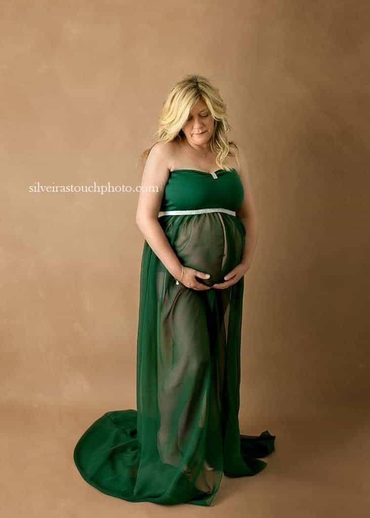maternity photography Morris County in studio session of pregnant mom to be wearing a green maternity gown
