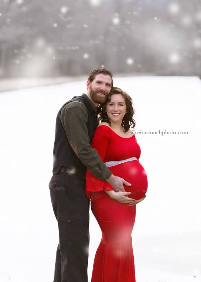 winter maternity photography of mama wearing red dress
