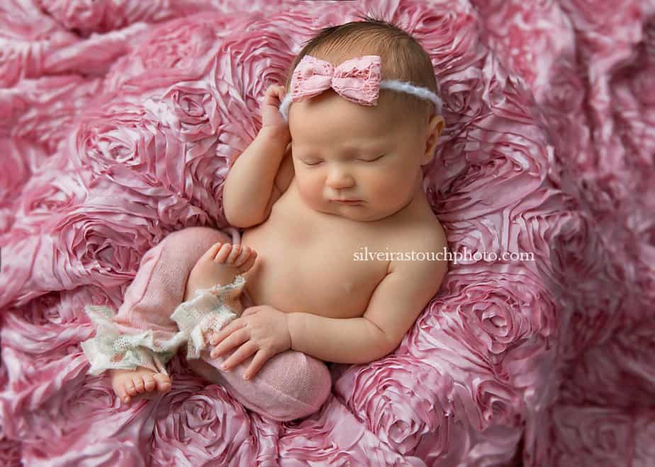 newborn baby girl laying on soft floral fabric sleeping
