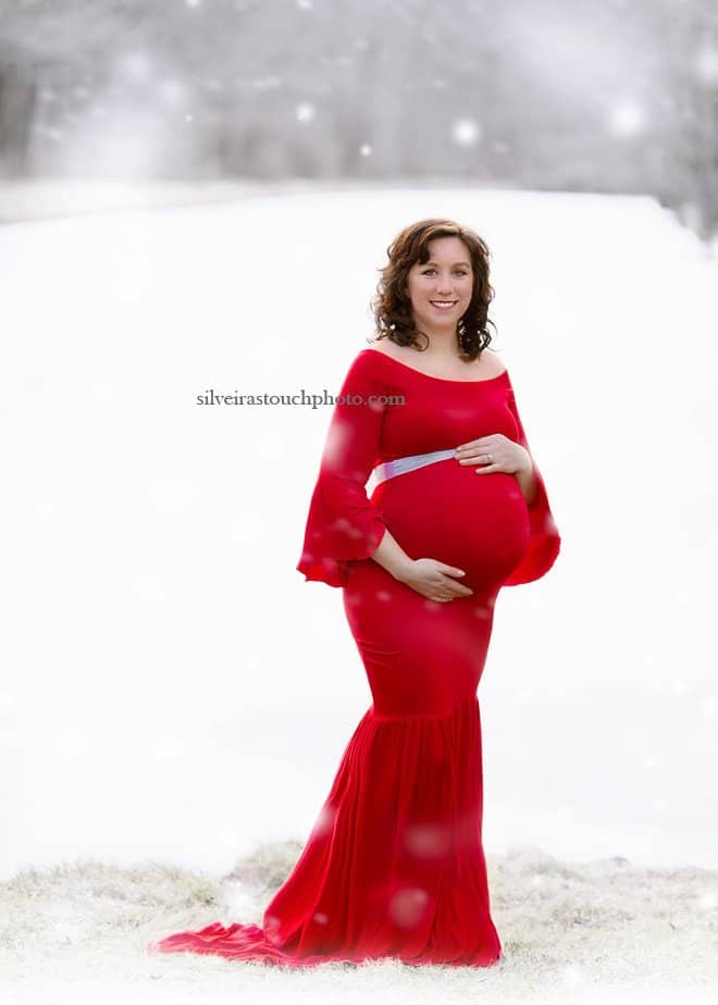 Maternity photogaphy in the snow of mom wearing red dress