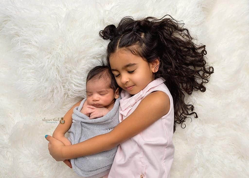 newborn poses with siblings