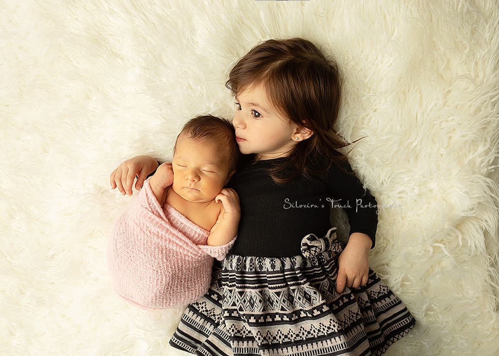 newborn sibling portrait kissing