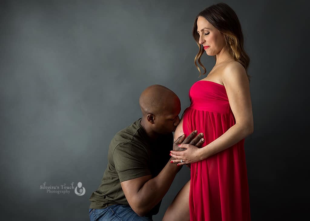 maternity photography session in studio with mom to be wearing red gown