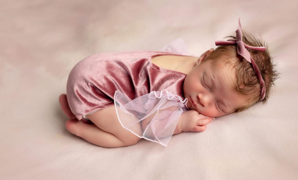 newborn baby in pink prop