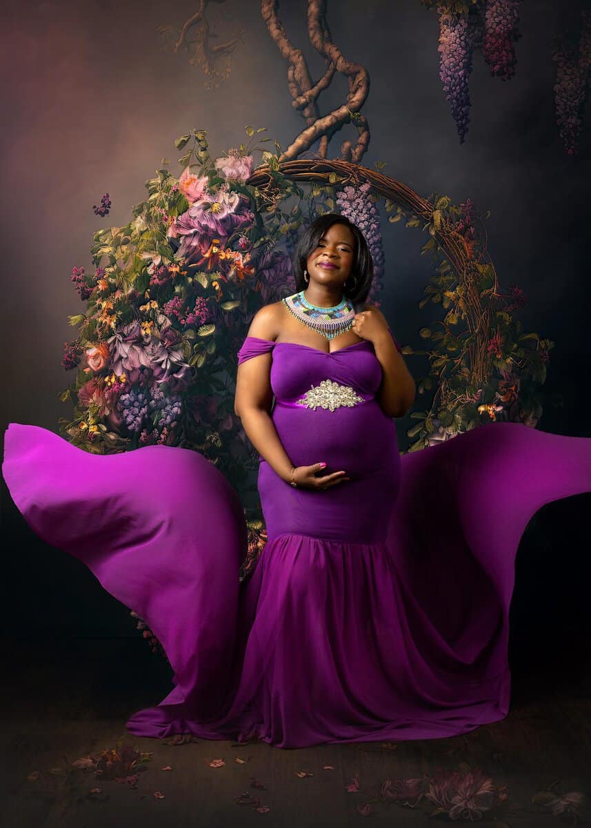 elegant plus size maternity portraits of mom wearing flowing purple gown in studio